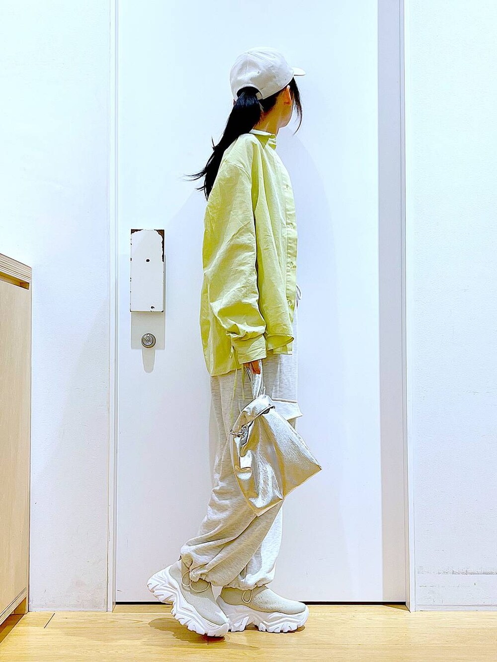 シルバー系のショルダーバッグ、ベージュ系のスウェットパンツ、グリーン系のシャツ/ブラウスを着用したレディースの春コーディネートの4枚目の写真