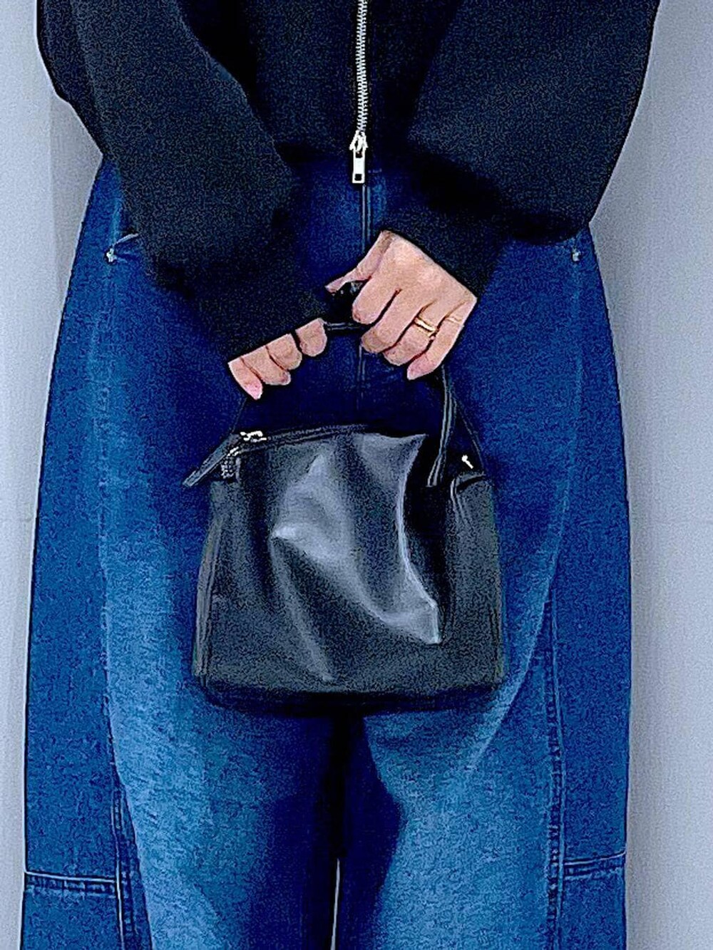 ブラック系のショルダーバッグ、ブルー系のデニムパンツ、ブラック系のスウェットを着用したレディースの春コーディネートの9枚目の写真