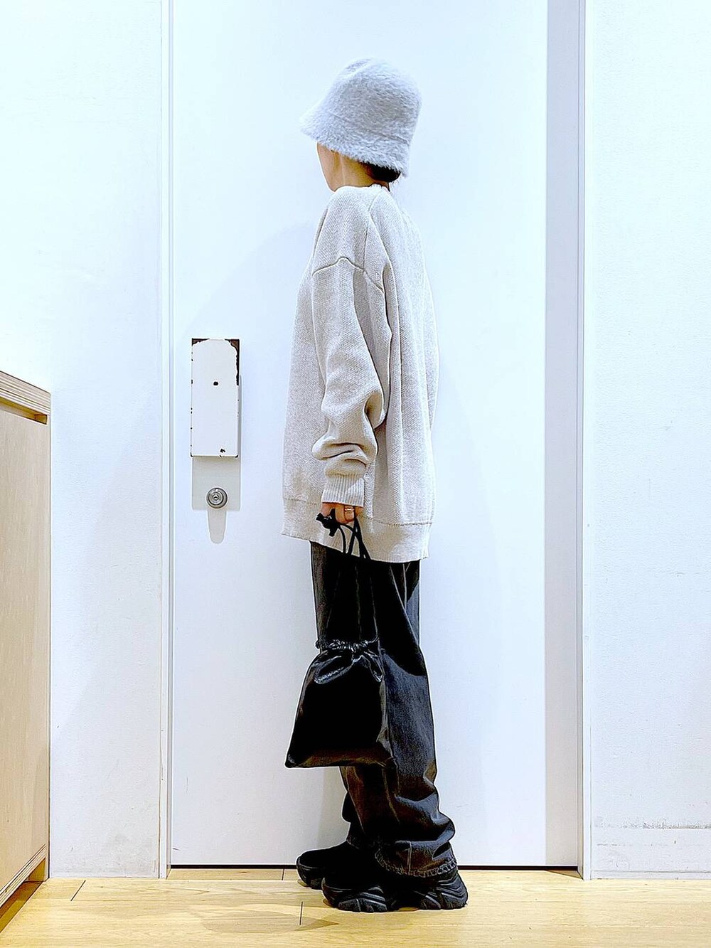 ブラック系のブーツ、ベージュ系のニット/セーター、ブルー系のデニムパンツを着用したレディースの冬コーディネートの3枚目の写真