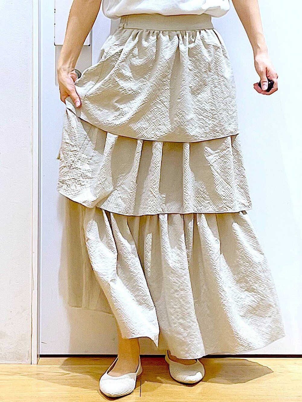 ベージュ系のスカート、ホワイト系のTシャツ/カットソー、その他のトートバッグを着用したレディースの春コーディネートの8枚目の写真