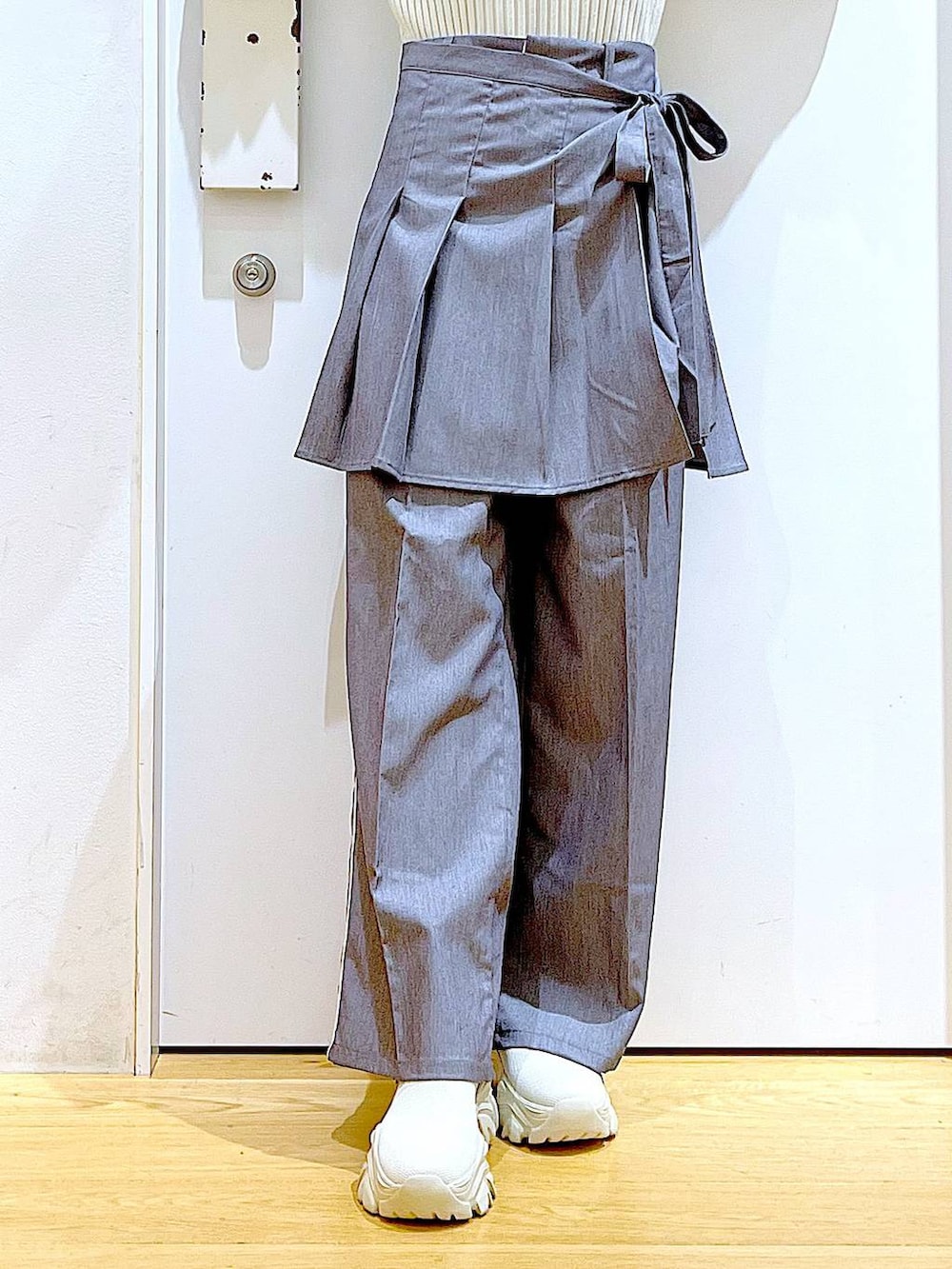 ホワイト系のニット/セーター、グレー系のスラックス、グレー系のスカートを着用したレディースの秋コーディネートの8枚目の写真