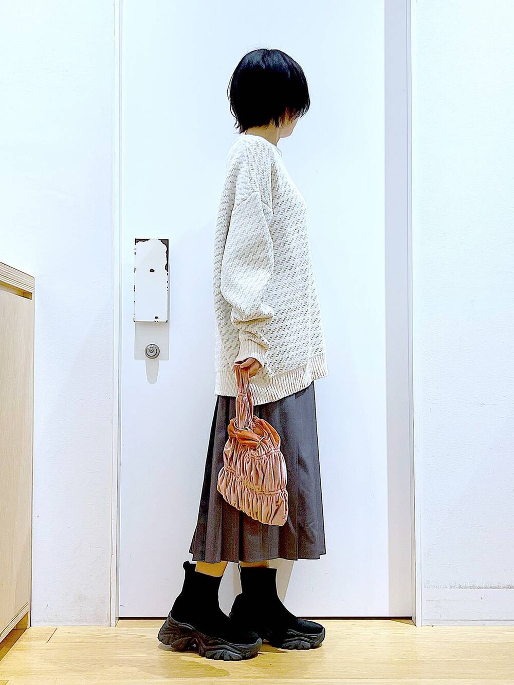 ベージュ系のニット/セーター、ピンク系のショルダーバッグ、ブラック系のブーツを着用したレディースの冬コーディネートの4枚目の写真