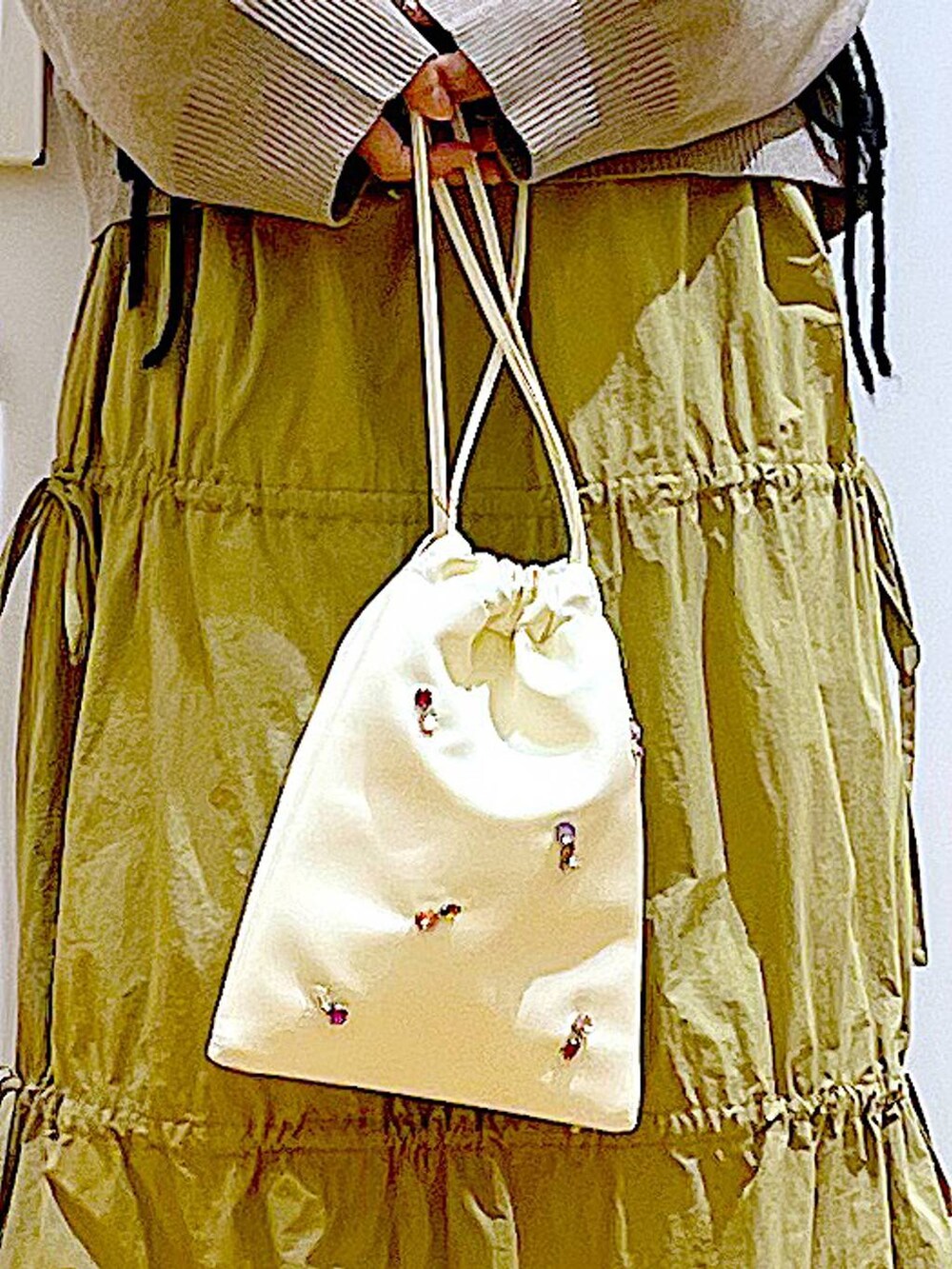 ホワイト系のショルダーバッグ、イエロー系のスカート、ベージュ系のブーツを着用したレディースの秋コーディネートの9枚目の写真