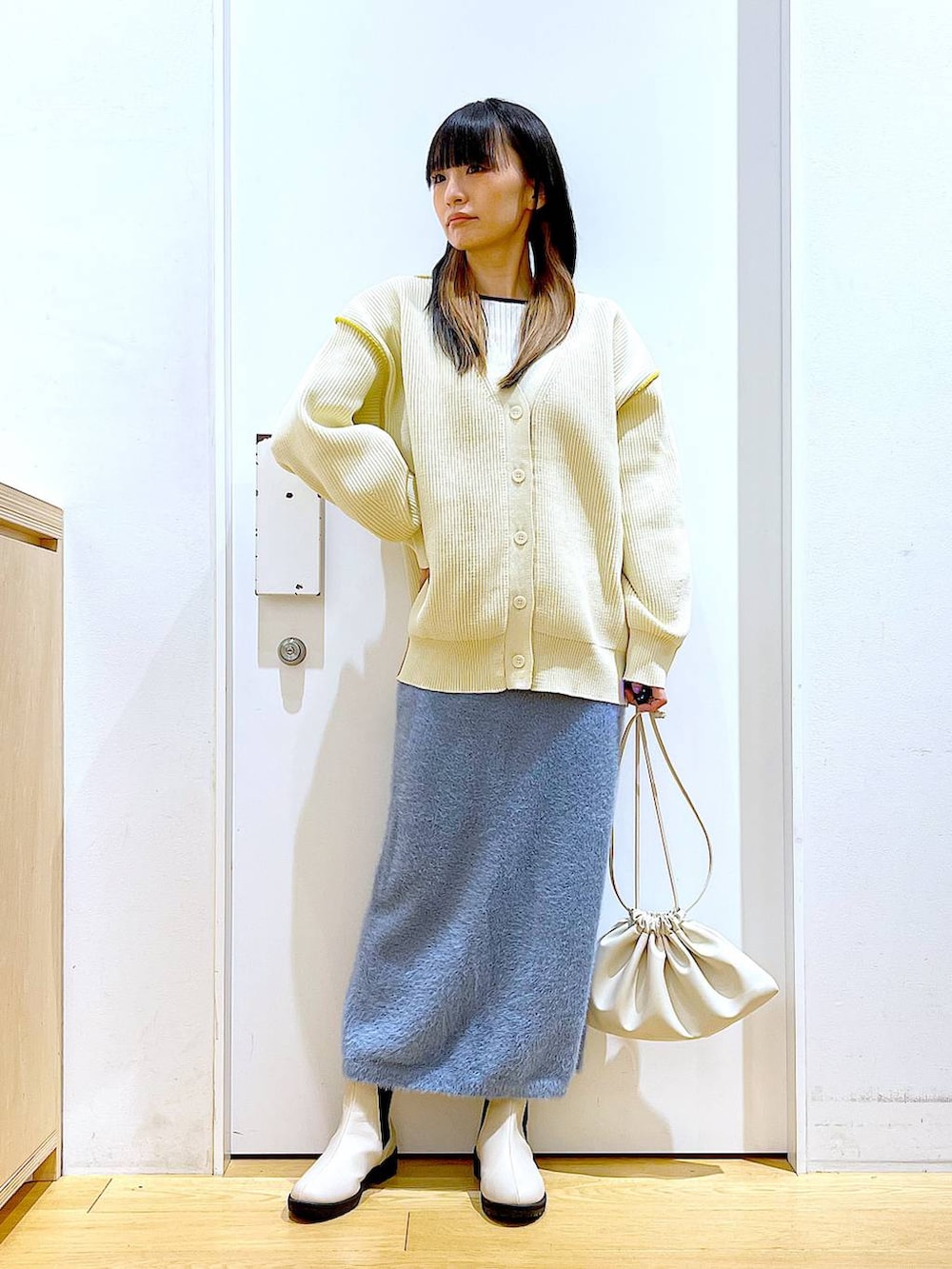 ベージュ系のブーツ、ベージュ系のニット/セーター、ベージュ系のショルダーバッグを着用したレディースの冬コーディネートの2枚目の写真