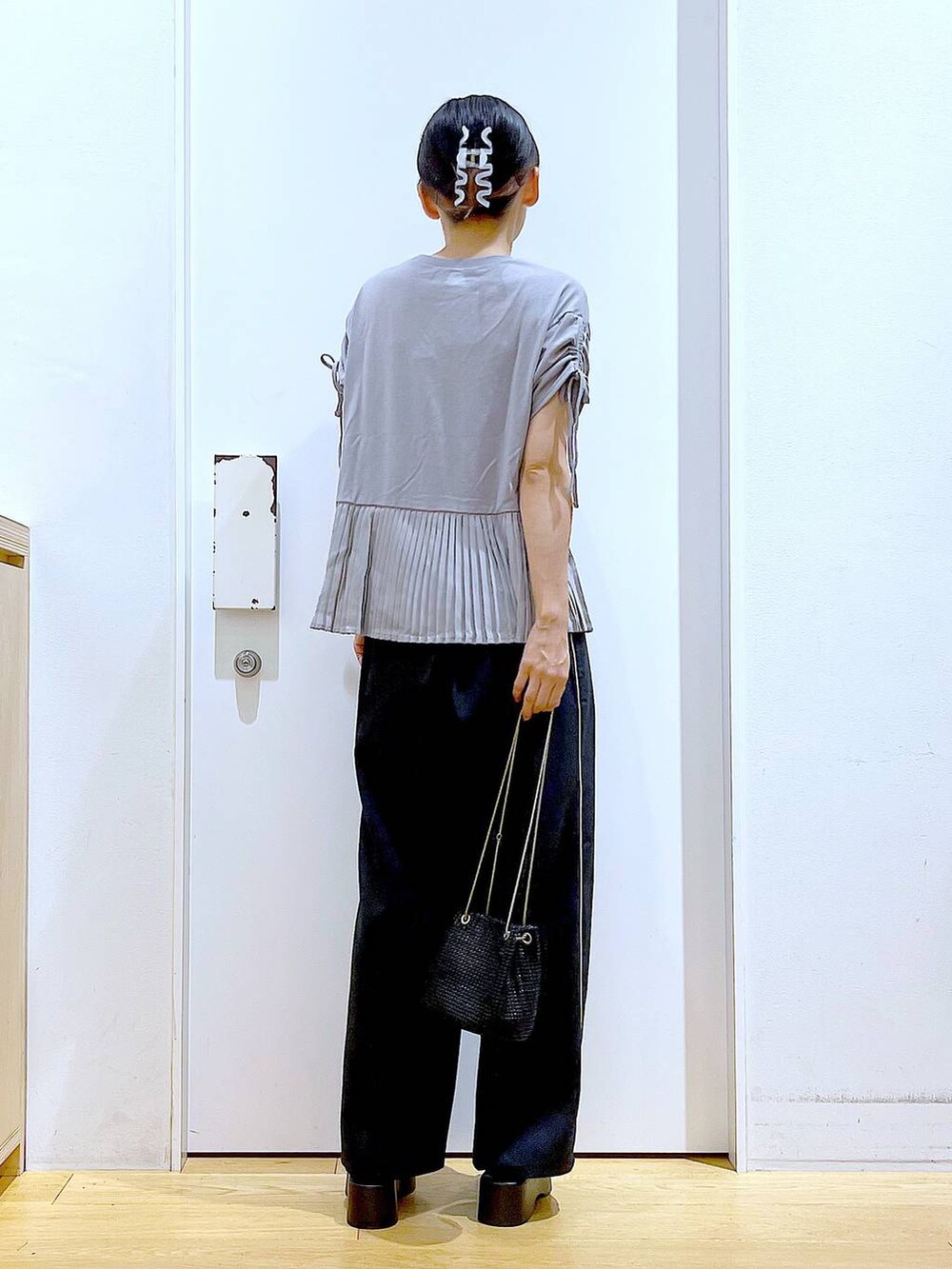 ブラック系のサンダル、ブラック系のスラックス、グレー系のTシャツ/カットソーを着用したレディースの秋コーディネートの5枚目の写真