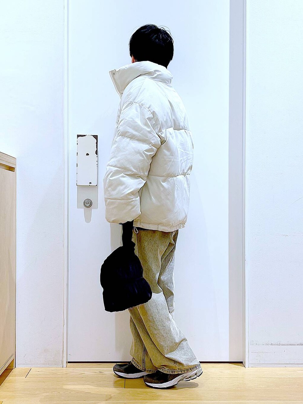 ベージュ系のブルゾン、ブラック系のショルダーバッグ、ベージュ系のデニムパンツを着用したレディースの冬コーディネートの3枚目の写真