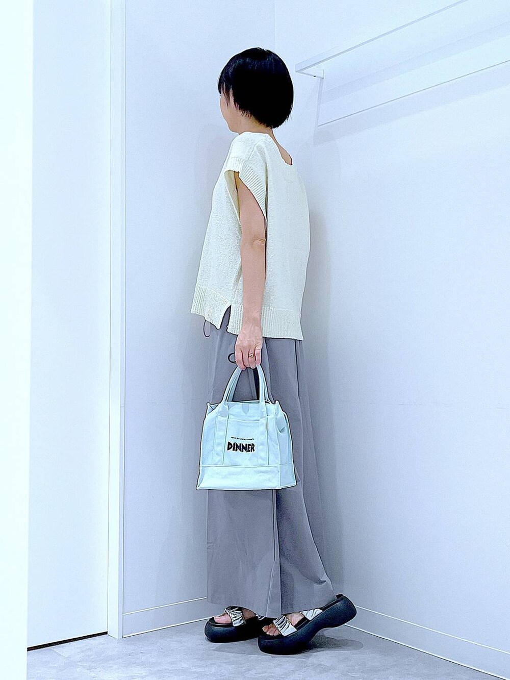 シルバー系のサンダル、グレー系のスカート、ホワイト系のベストを着用したレディースの夏コーディネートの3枚目の写真