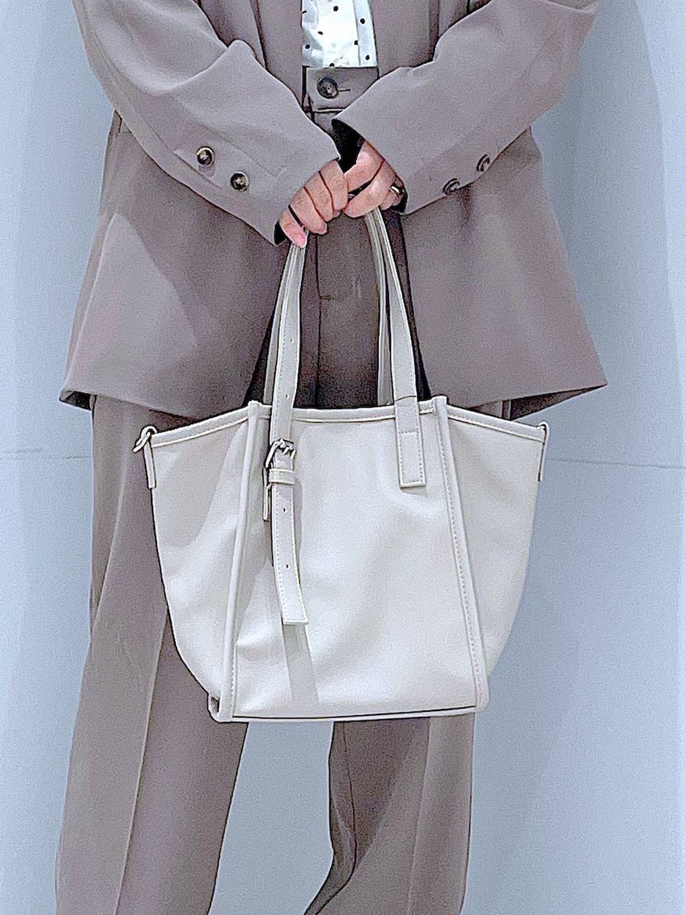 ブラック系のブーツ、グレー系のトートバッグ、ブラウン系のノーカラージャケットを着用したレディースの冬コーディネートの9枚目の写真