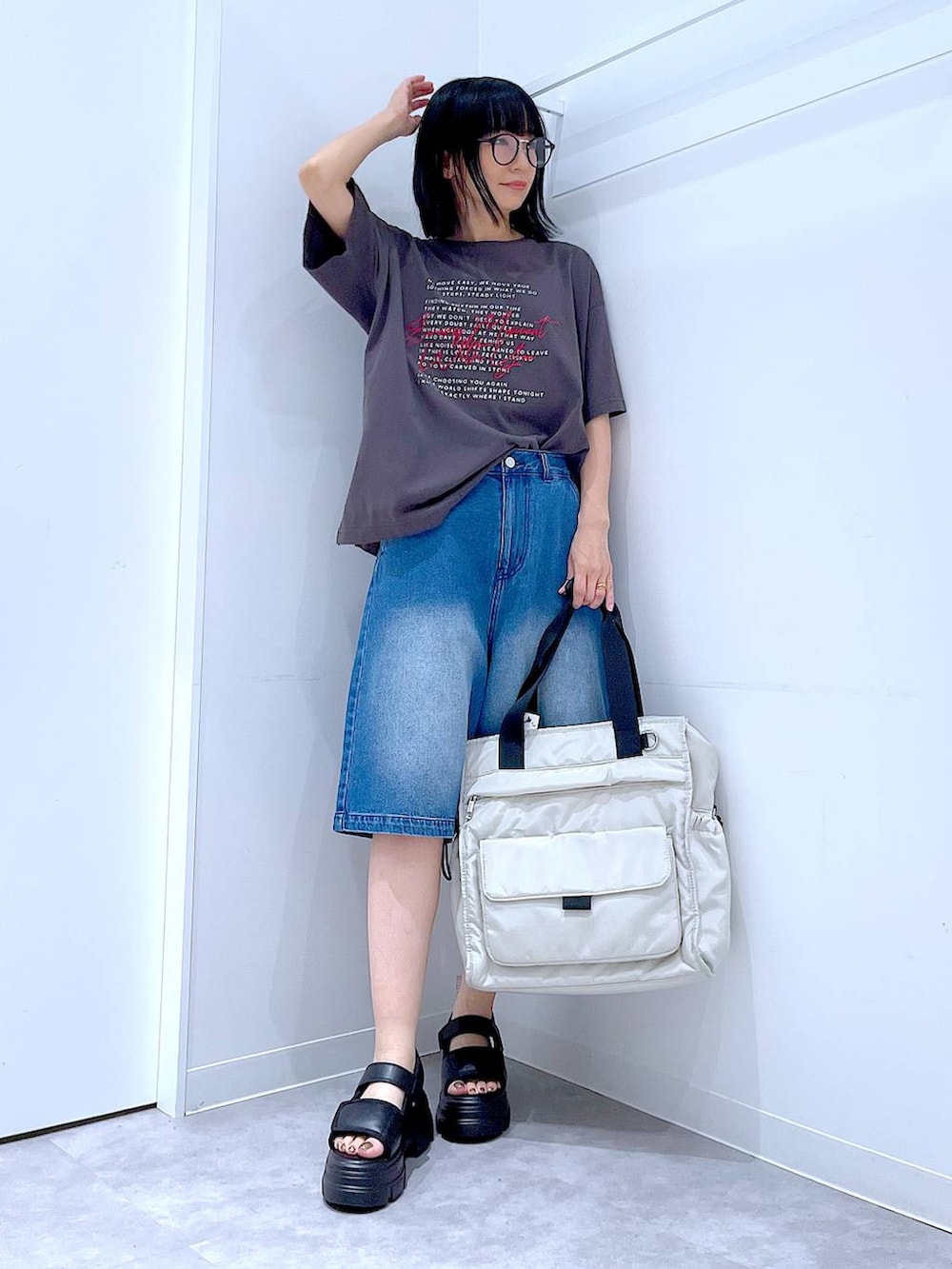 ブラック系のサンダル、ホワイト系のトートバッグ、グレー系のTシャツ/カットソーを着用したレディースの夏コーディネートの2枚目の写真