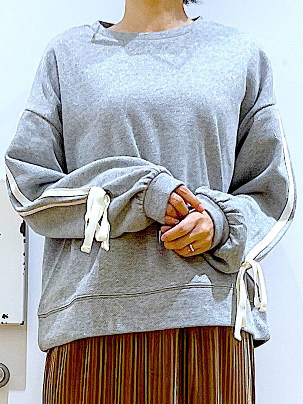 グレー系のショルダーバッグ、ブラウン系のスカート、ベージュ系のブーツを着用したレディースの秋コーディネートの7枚目の写真