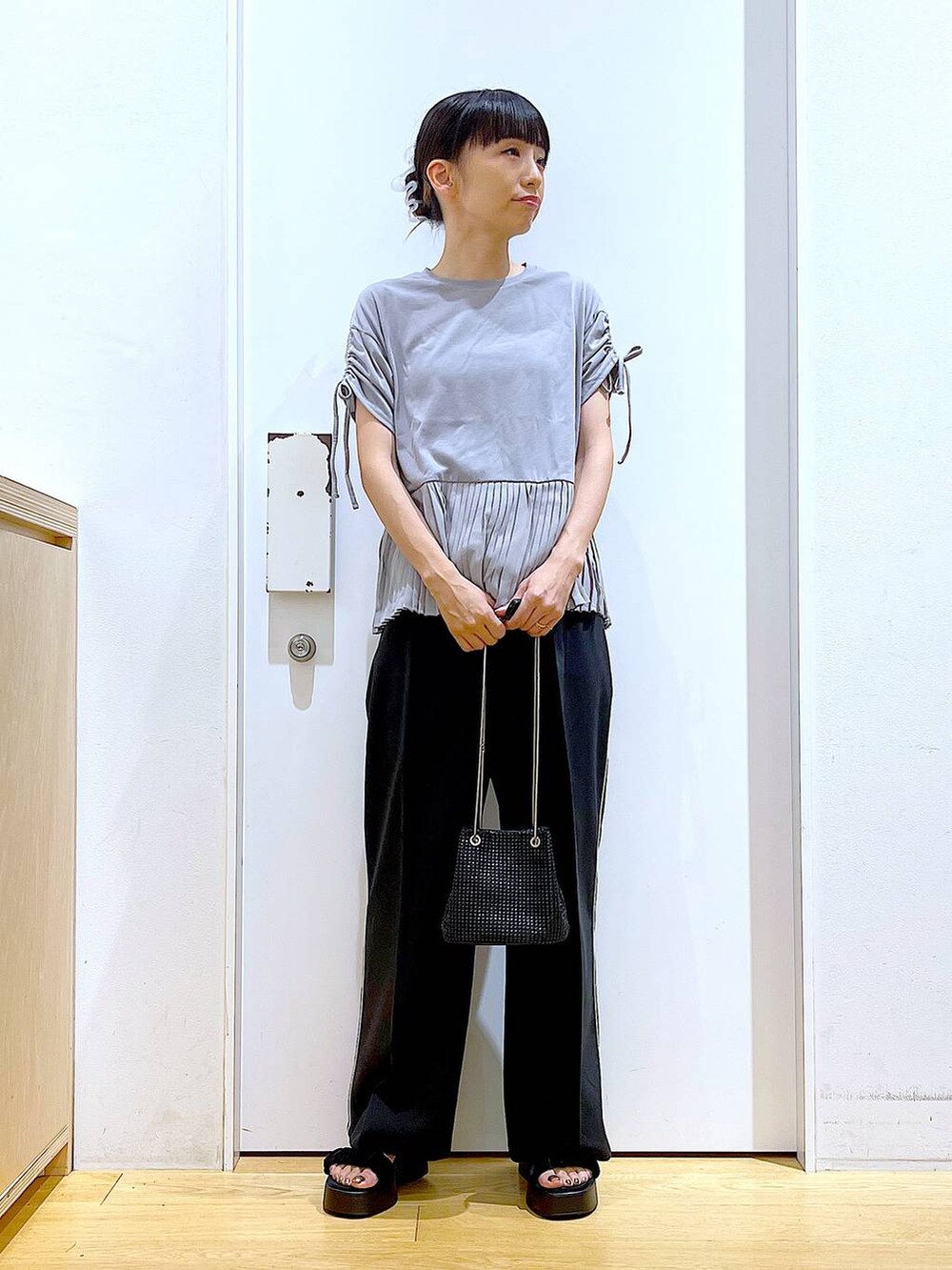 ブラック系のサンダル、ブラック系のスラックス、グレー系のTシャツ/カットソーを着用したレディースの秋コーディネートの2枚目の写真