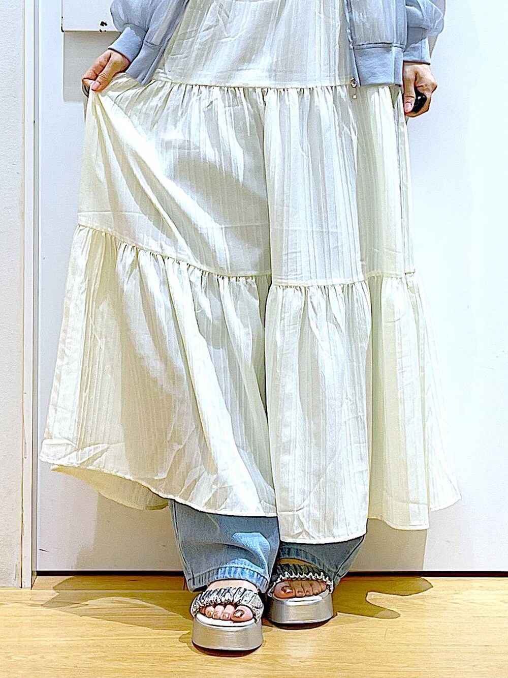 ブルー系のデニムパンツ、シルバー系のトートバッグ、シルバー系のサンダルを着用したレディースの夏コーディネートの8枚目の写真