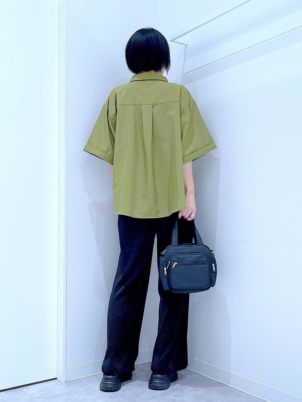 ブラック系のスニーカー、ブラック系のショルダーバッグ、グリーン系のシャツ/ブラウスを着用したレディースの夏コーディネートの5枚目の写真