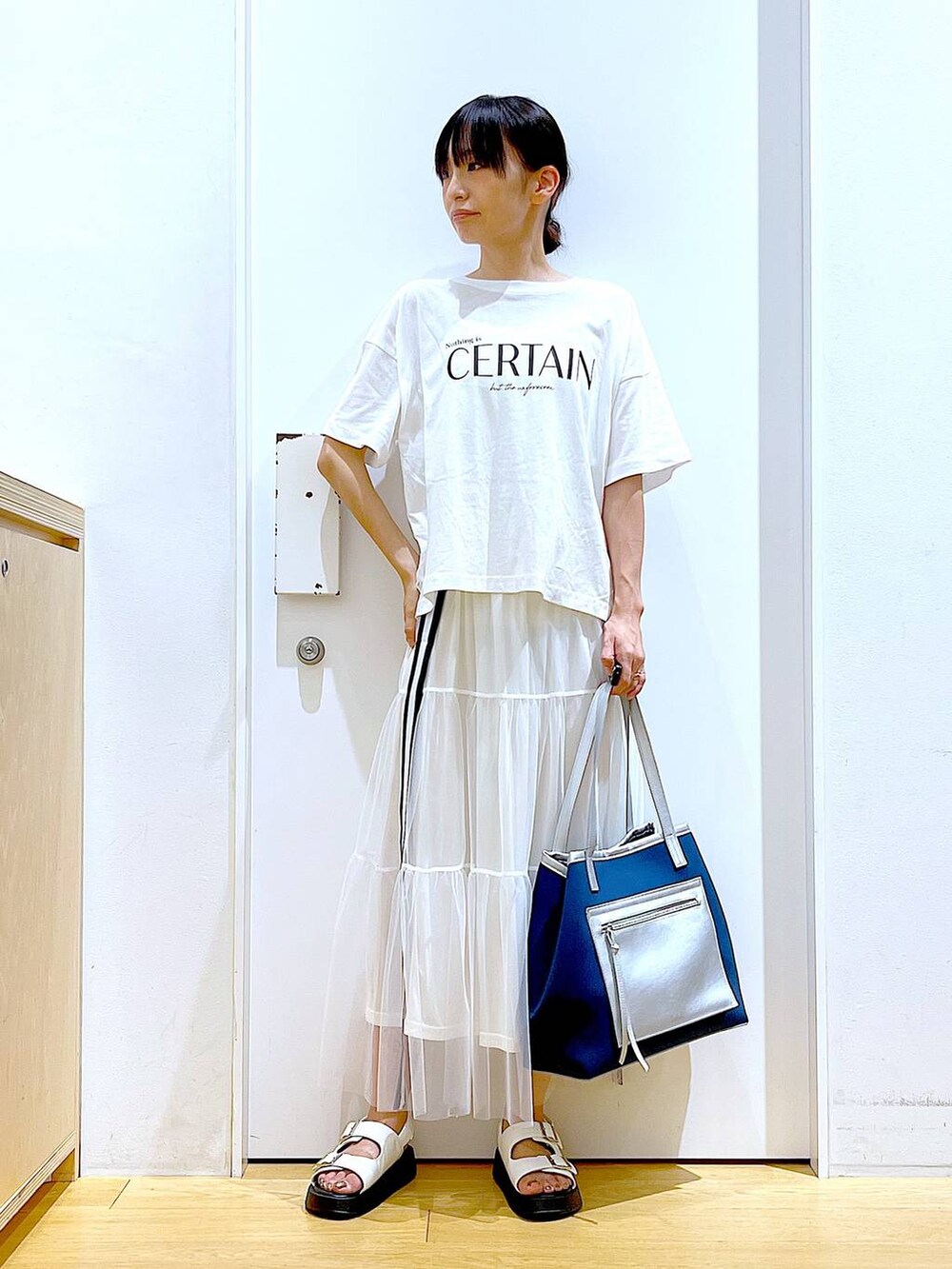 ホワイト系のサンダル、ホワイト系のスカート、ホワイト系のTシャツ/カットソーを着用したレディースの夏コーディネートの2枚目の写真