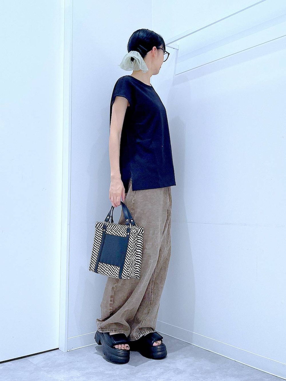 ブラウン系のデニムパンツ、その他のショルダーバッグ、ブラック系のサンダルを着用したレディースの夏コーディネートの4枚目の写真