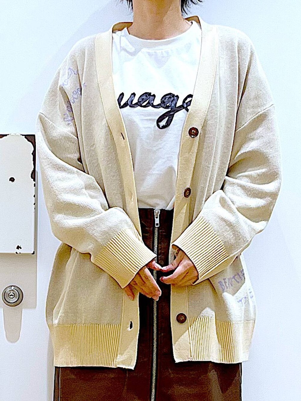 ブラウン系のスカート、ブラック系のショルダーバッグ、ブラック系のパンプスを着用したレディースの秋コーディネートの7枚目の写真