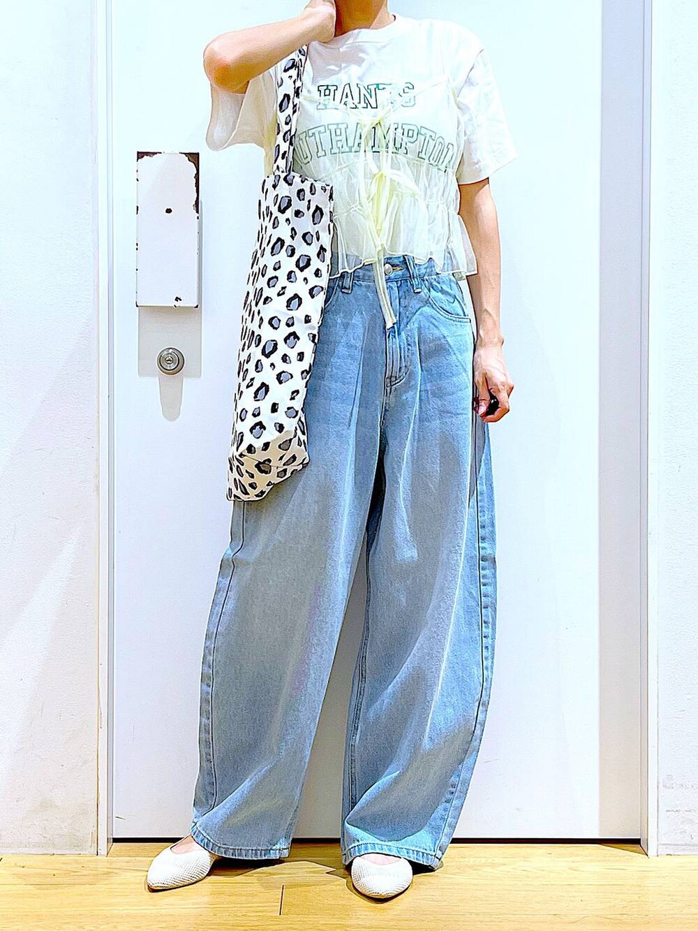 ブルー系のデニムパンツ、イエロー系のキャミソール、ホワイト系のトートバッグを着用したレディースの春コーディネートの6枚目の写真
