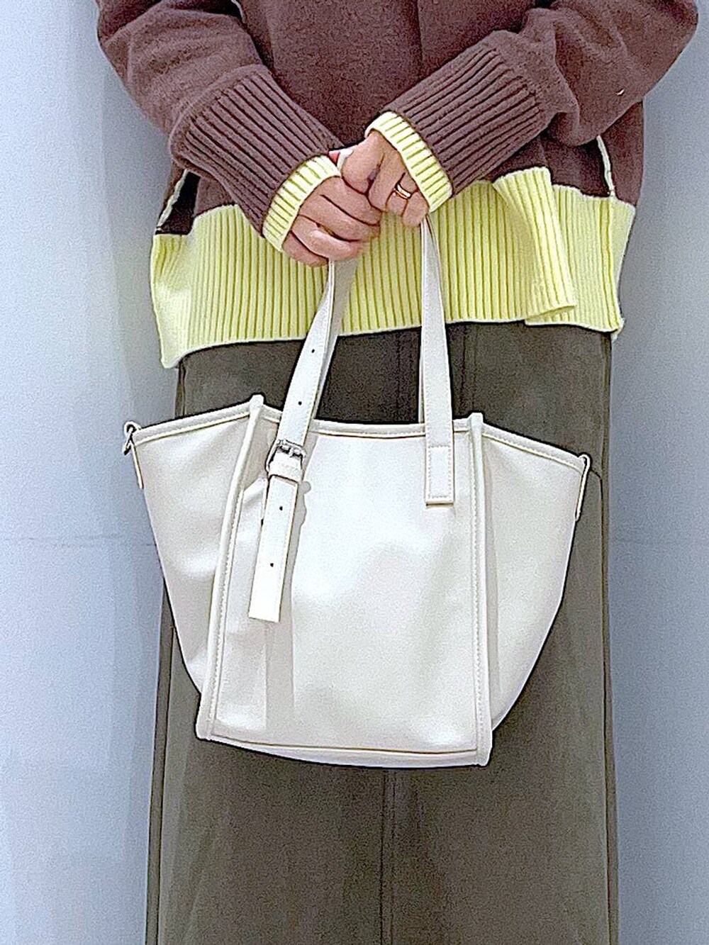 ブラック系のブーツ、グリーン系のスカート、ホワイト系のトートバッグを着用したレディースの冬コーディネートの9枚目の写真