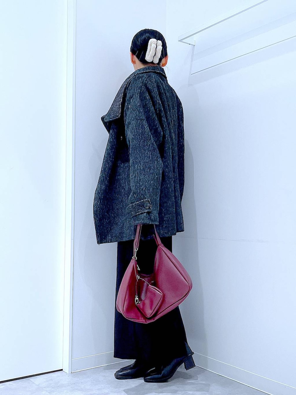 ブラック系のスカート、ブラック系のステンカラーコート、ブラック系のブーツを着用したレディースの冬コーディネートの3枚目の写真