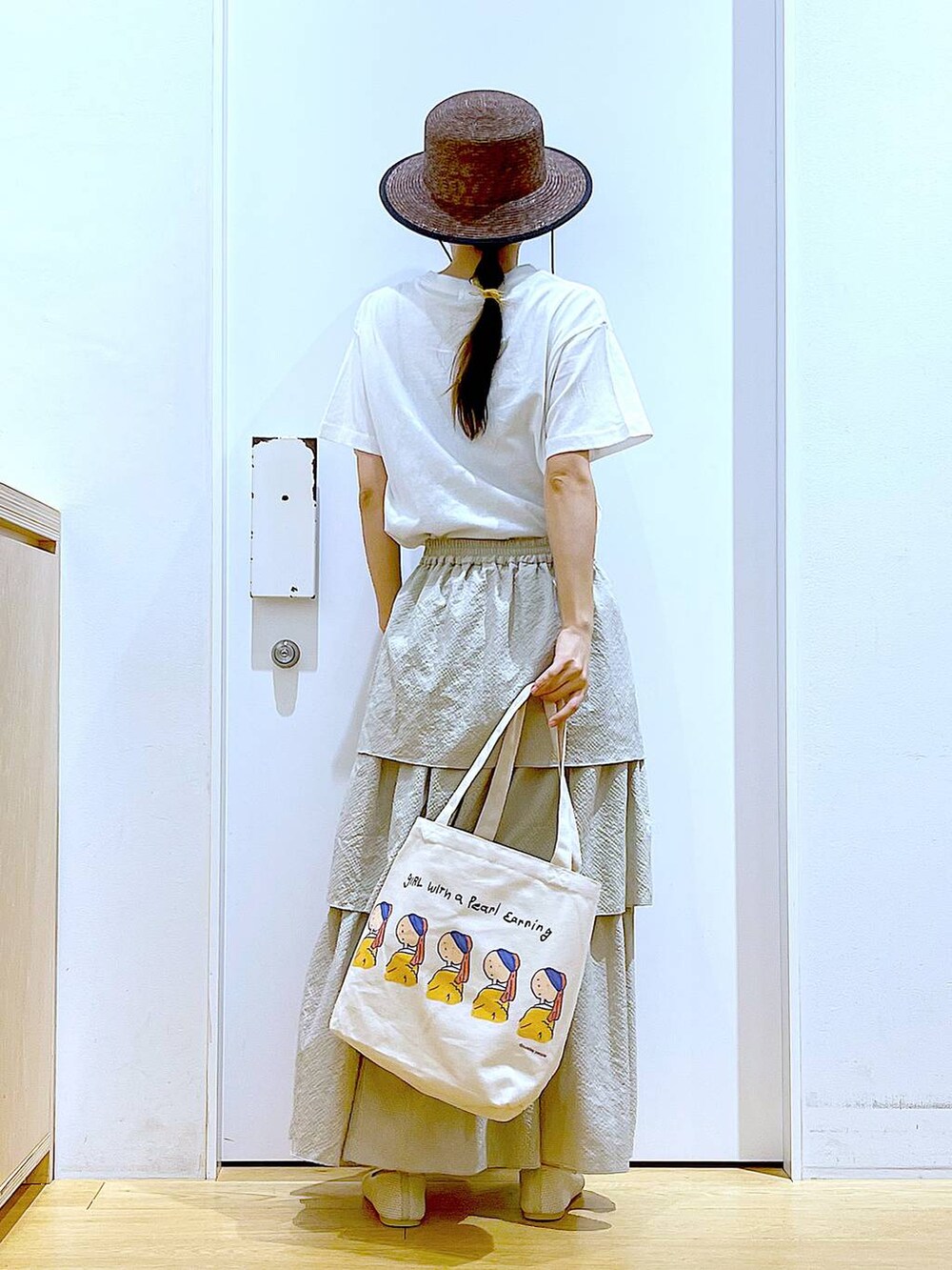ベージュ系のスカート、ホワイト系のTシャツ/カットソー、その他のトートバッグを着用したレディースの春コーディネートの5枚目の写真