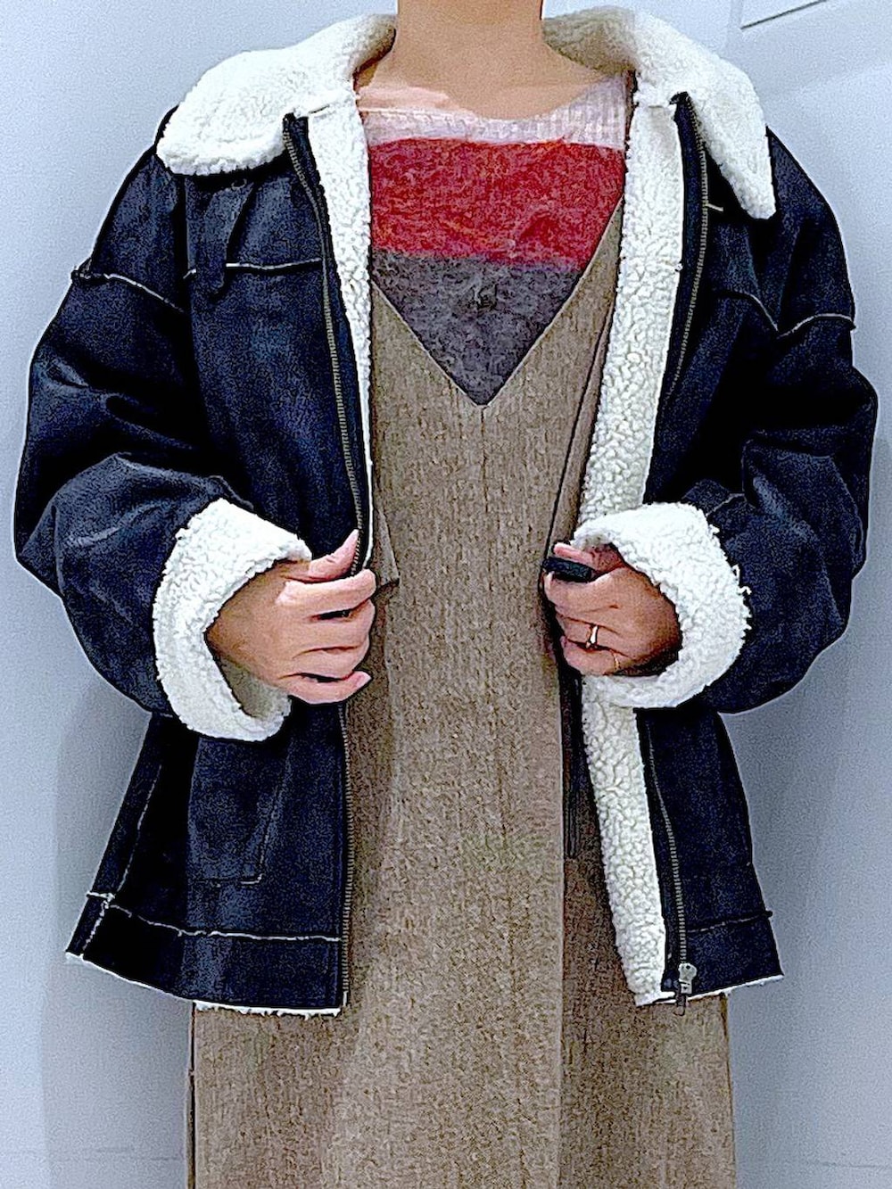 ブラック系のムートンコート、ベージュ系のショルダーバッグ、ブラック系のブーツを着用したレディースの冬コーディネートの7枚目の写真