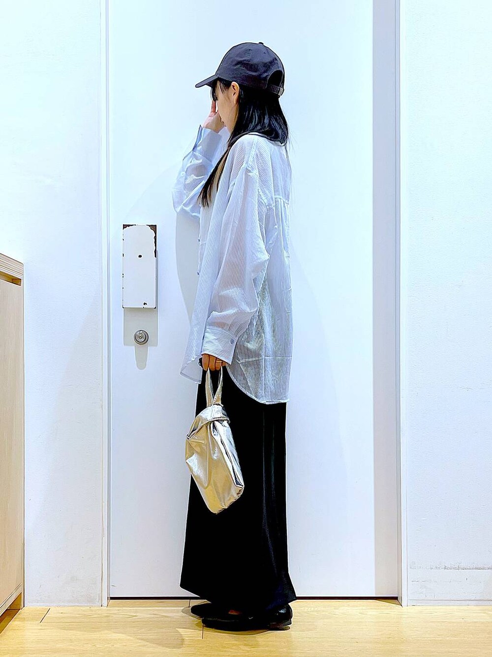 シルバー系のショルダーバッグ、ブラック系のパンプス、ブラック系のスカートを着用したレディースの春コーディネートの3枚目の写真