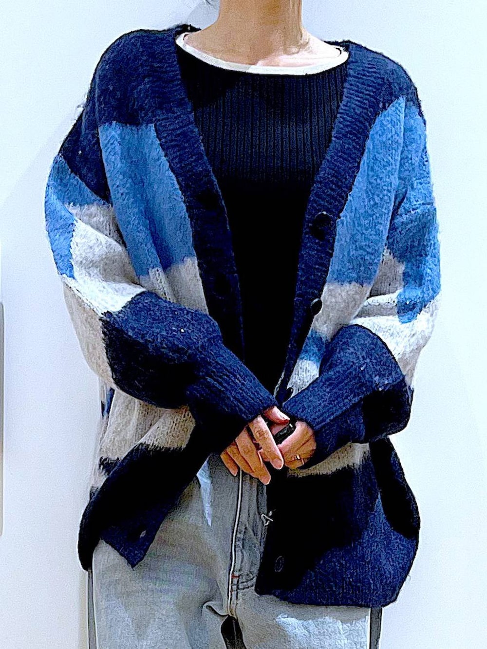 ベージュ系のショルダーバッグ、ベージュ系のブーツ、ブラック系のニット/セーターを着用したレディースの冬コーディネートの7枚目の写真