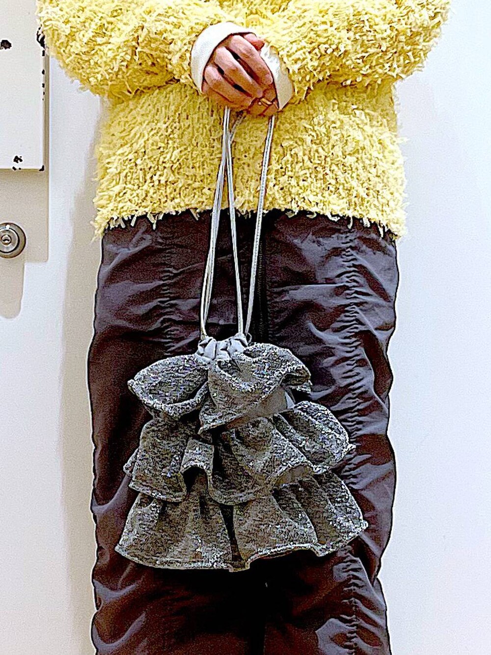 シルバー系のショルダーバッグ、グレー系のスカート、ホワイト系のスニーカーを着用したレディースの春コーディネートの9枚目の写真