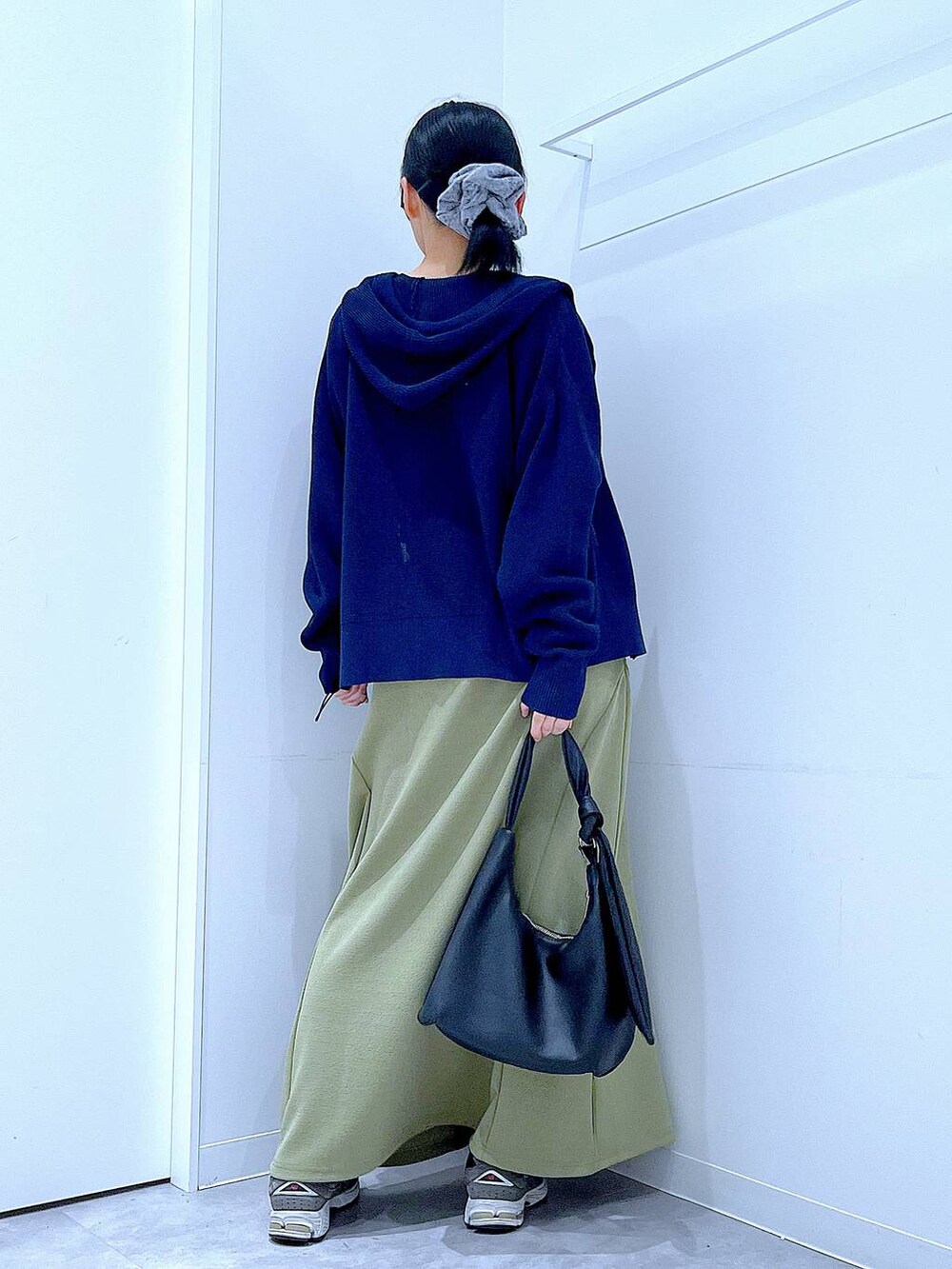 ブラック系のTシャツ/カットソー、ブラック系のショルダーバッグ、グリーン系のスカートを着用したレディースの春コーディネートの5枚目の写真