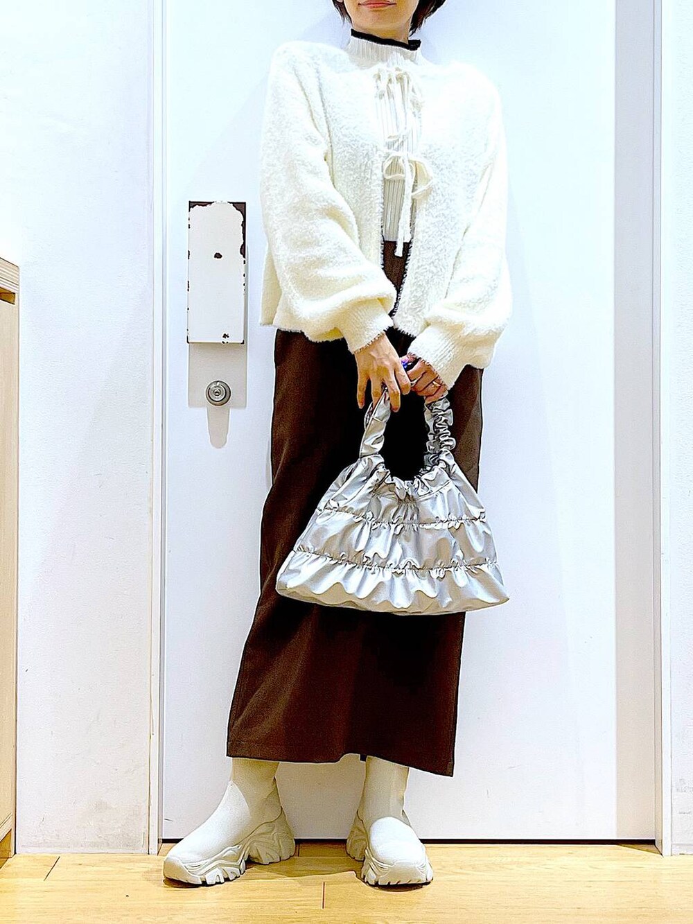 ベージュ系のニット/セーター、ベージュ系のブーツ、ブラウン系のサロペット/オーバーオールを着用したレディースの冬コーディネートの6枚目の写真