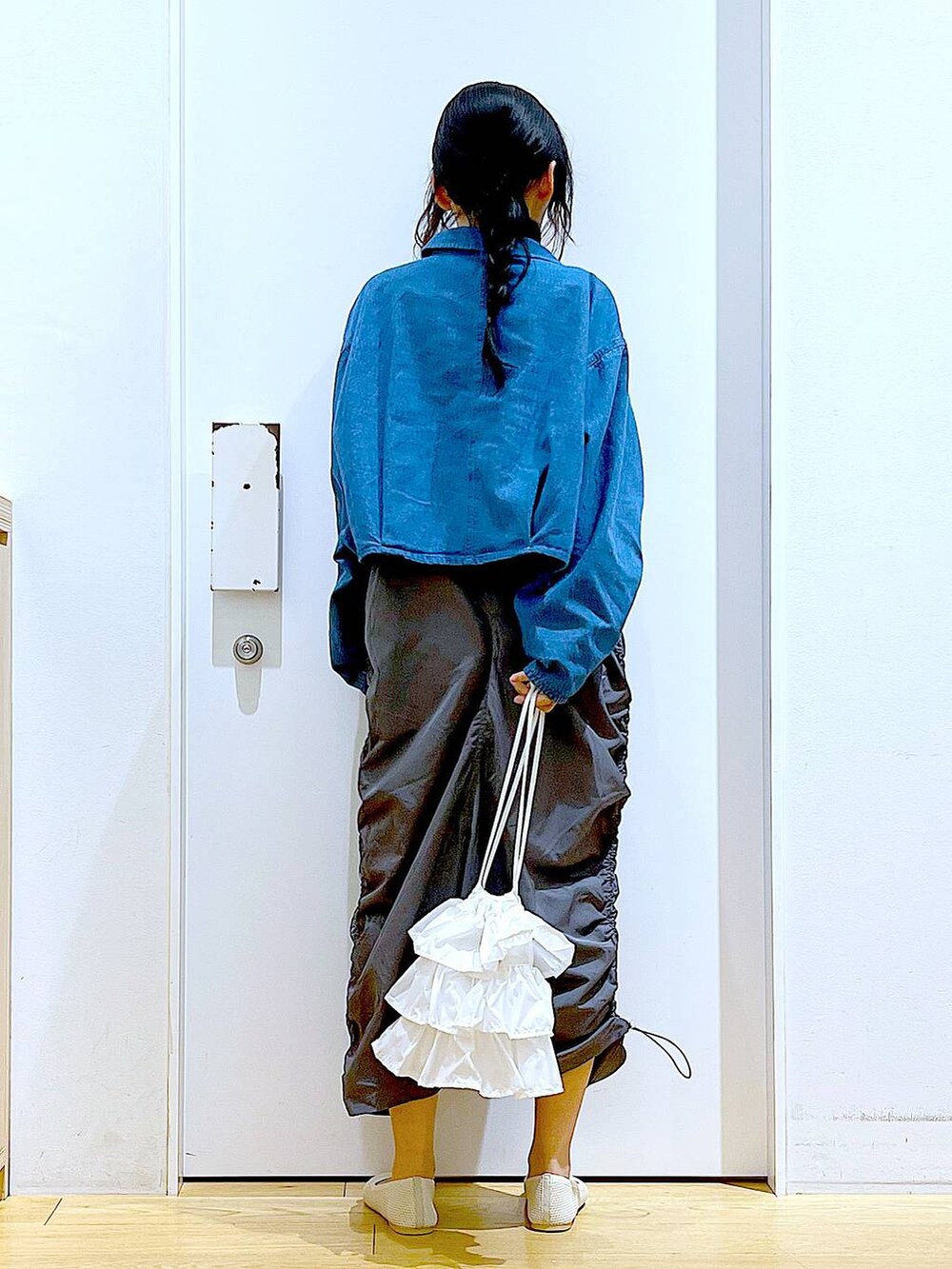 ブルー系のデニムジャケット、ホワイト系のショルダーバッグ、グレー系のワンピースを着用したレディースの春コーディネートの5枚目の写真