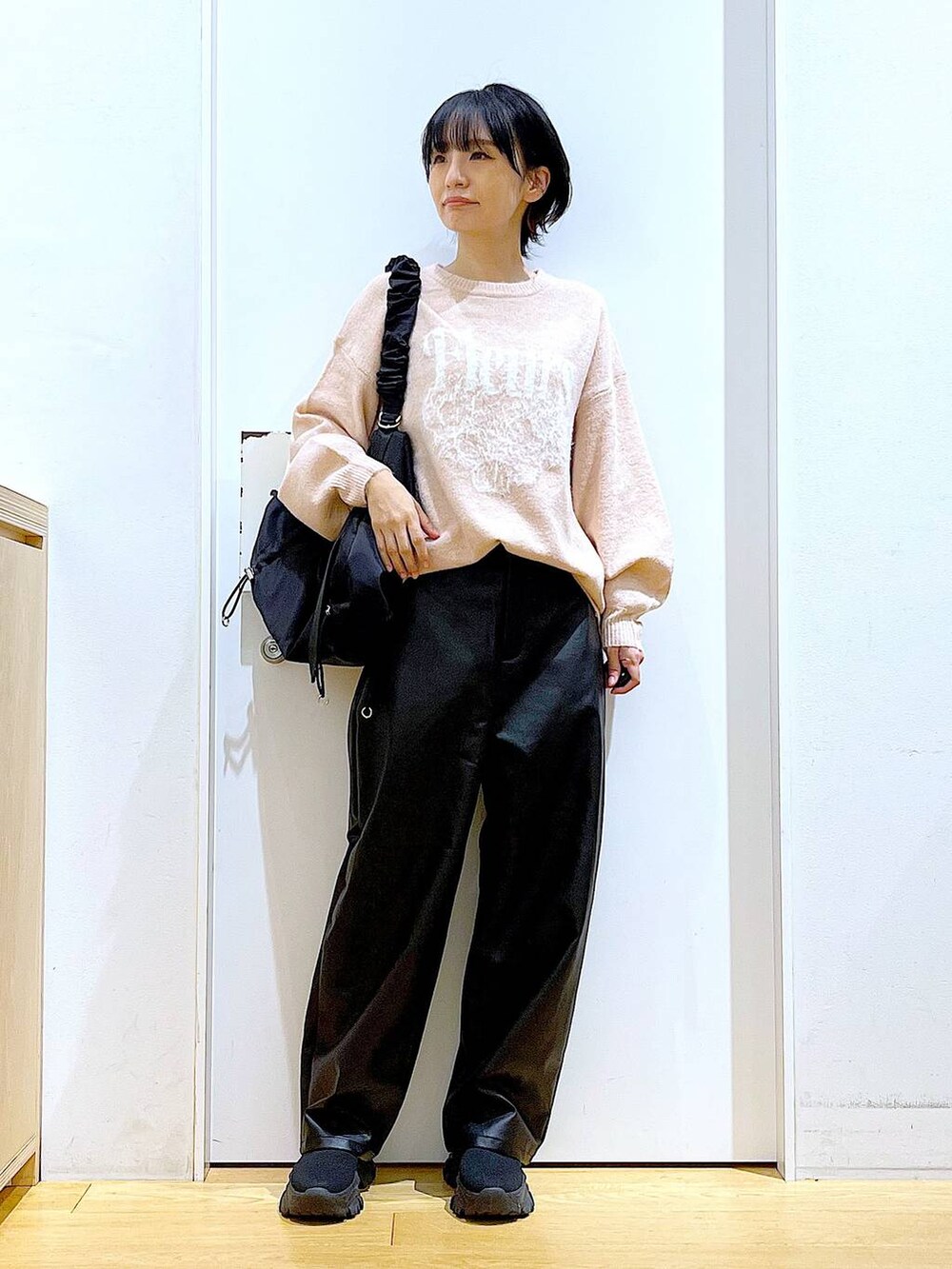 ブラック系のショルダーバッグ、ブラック系のブーツ、ブラック系のその他パンツを着用したレディースの冬コーディネートの2枚目の写真