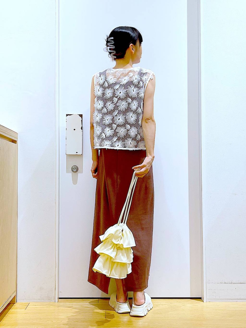 ホワイト系のサンダル、レッド系のワンピース、ホワイト系のベストを着用したレディースの夏コーディネートの5枚目の写真