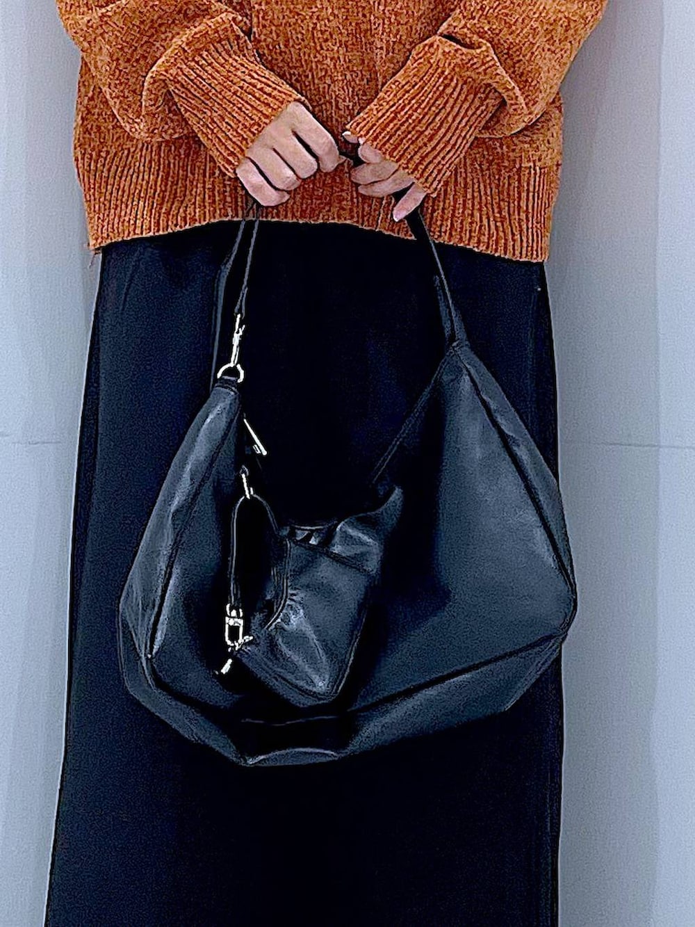 ブラック系のスカート、ブラック系のブーツ、ブラック系のショルダーバッグを着用したレディースの冬コーディネートの9枚目の写真