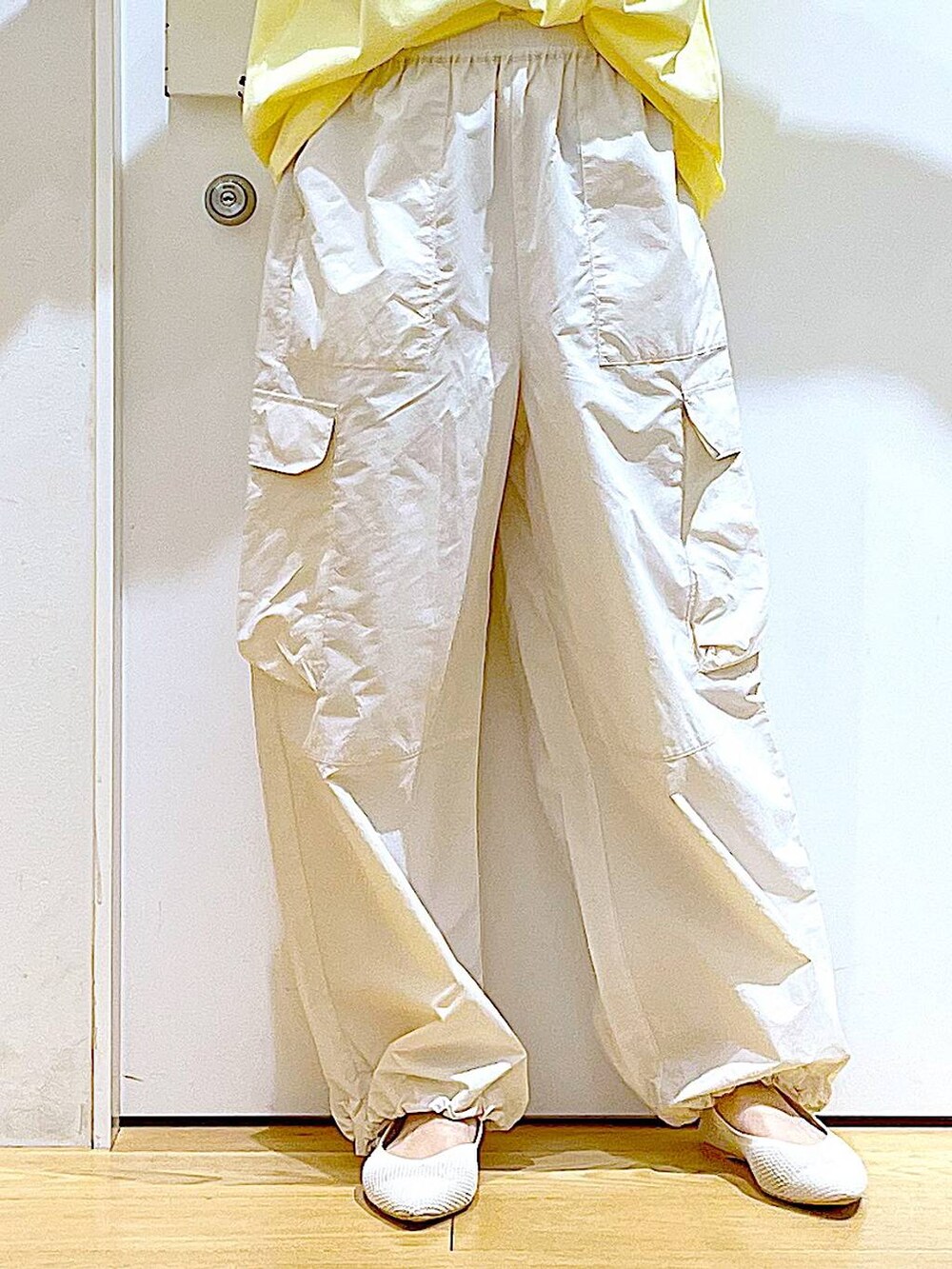 グレー系のトートバッグ、ホワイト系のカーゴパンツ、ホワイト系のパンプスを着用したレディースの春コーディネートの8枚目の写真