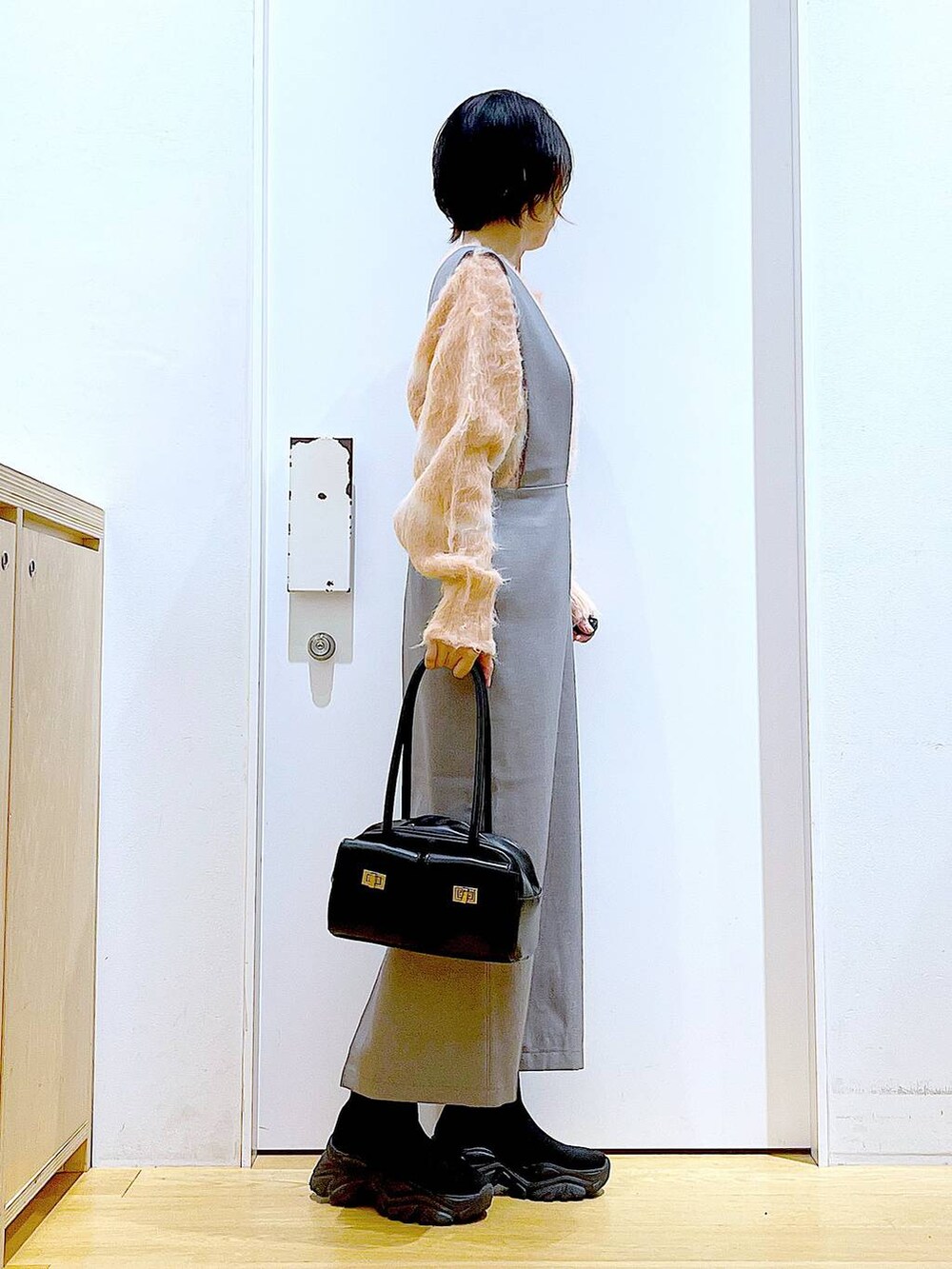 ピンク系のニット/セーター、ブラック系のハンドバッグ、ブラック系のブーツを着用したレディースの冬コーディネートの4枚目の写真