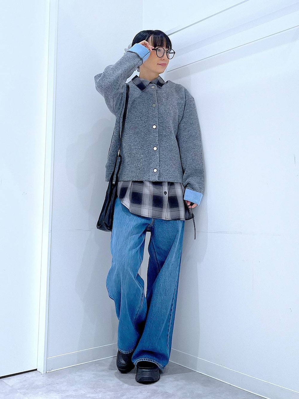 ブルー系のデニムパンツ、ブラック系のシャツ/ブラウス、ブラック系のショルダーバッグを着用したレディースの秋コーディネートの2枚目の写真