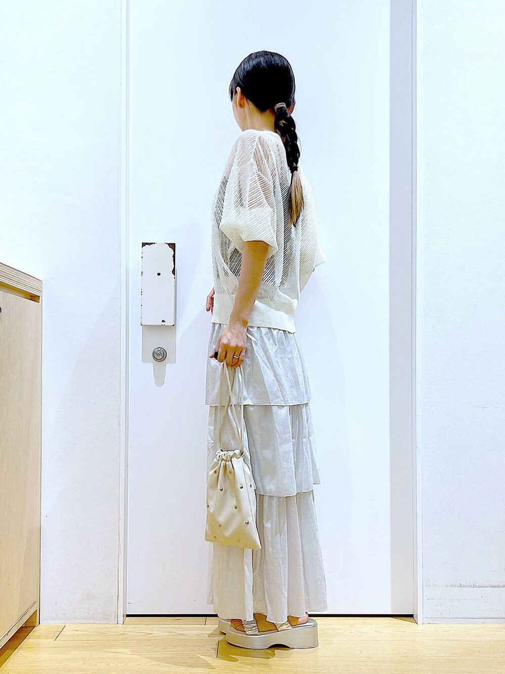 シルバー系のサンダル、ホワイト系のショルダーバッグ、シルバー系のスカートを着用したレディースの夏コーディネートの3枚目の写真