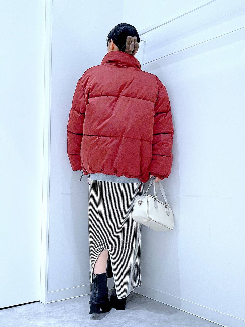 ブラウン系のブルゾン、ベージュ系のスカート、ブラック系のブーツを着用したレディースの冬コーディネートの5枚目の写真