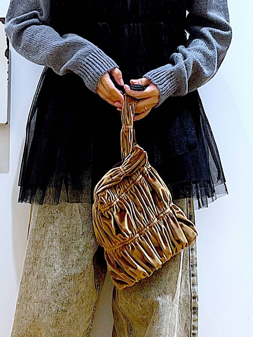 ブラック系のブーツ、イエロー系のショルダーバッグ、ベージュ系のデニムパンツを着用したレディースの秋コーディネートの9枚目の写真