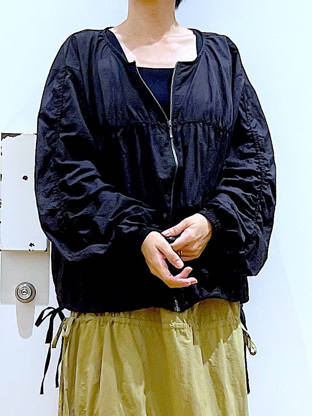 ブラック系のショルダーバッグ、ブラック系のローファー、イエロー系のスカートを着用したレディースの秋コーディネートの7枚目の写真