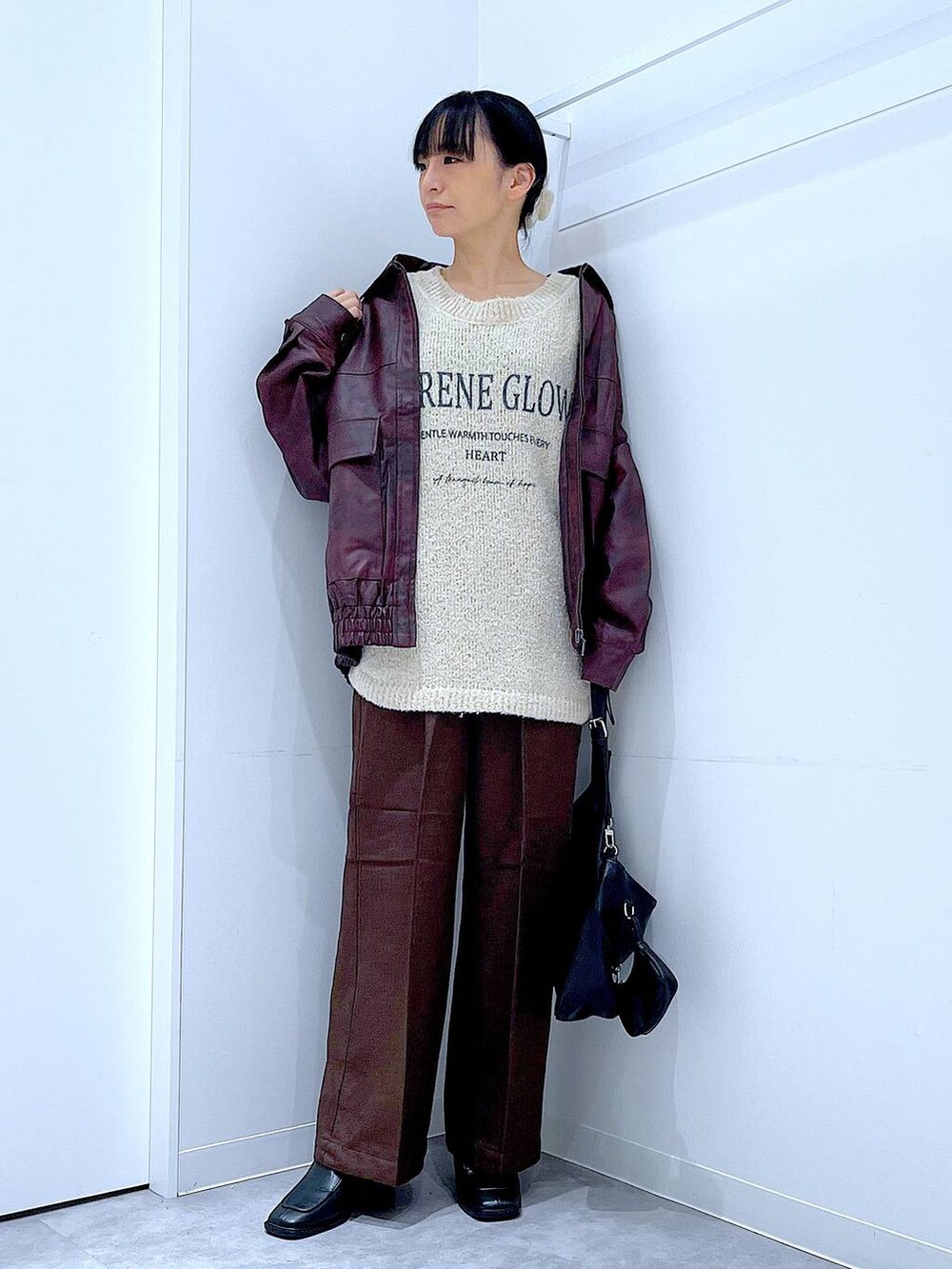 レッド系のブルゾン、ホワイト系のニット/セーター、ブラック系のブーツを着用したレディースの秋コーディネートの2枚目の写真