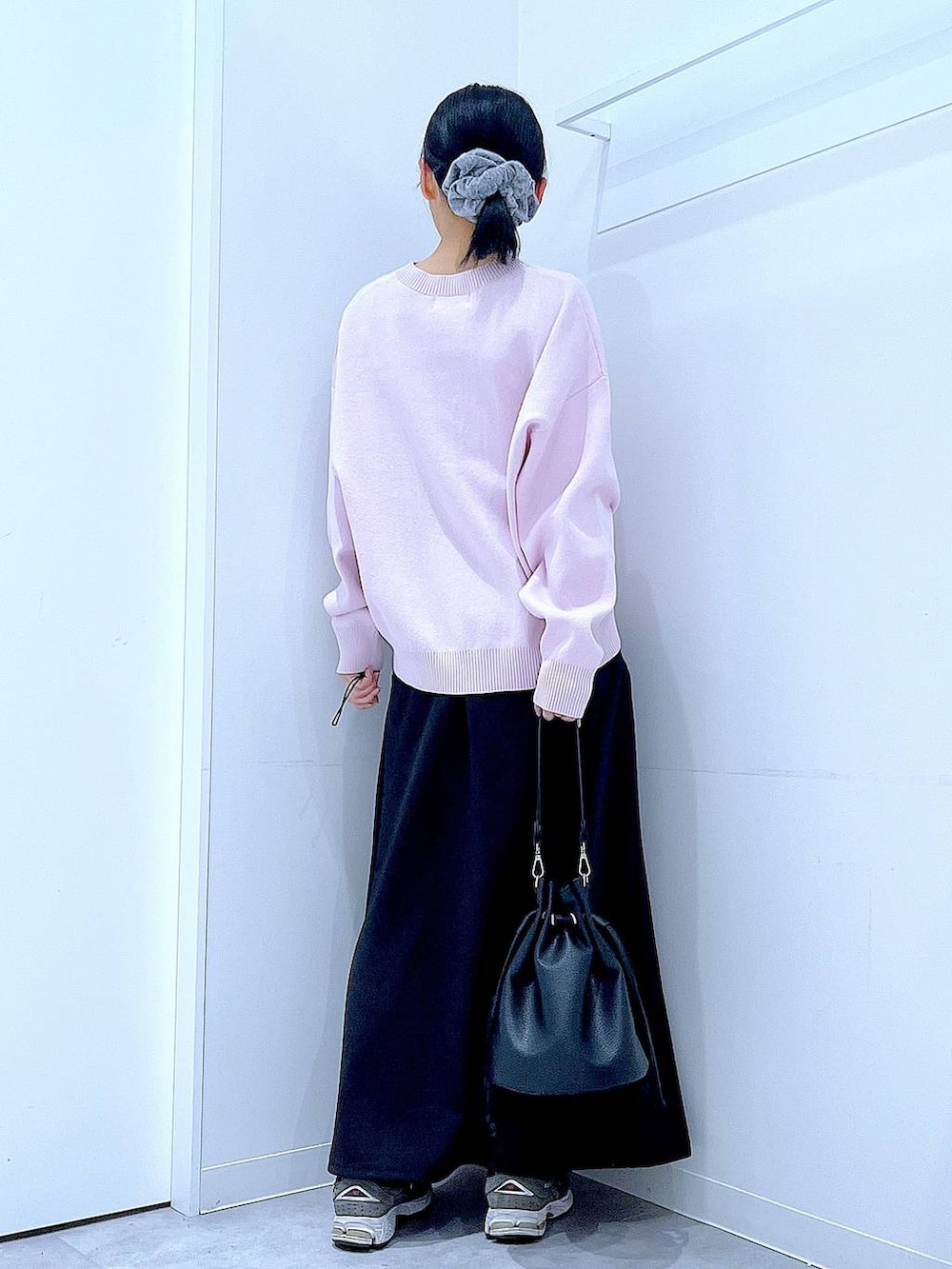 ピンク系のニット/セーター、ブラック系のショルダーバッグ、ブラック系のスカートを着用したレディースの春コーディネートの5枚目の写真