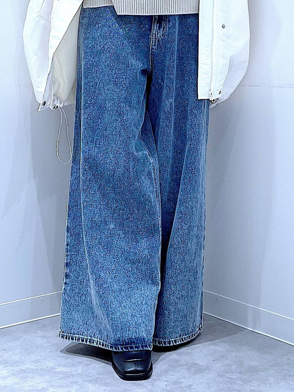 ホワイト系のブルゾン、ブルー系のデニムパンツ、ホワイト系のショルダーバッグを着用したレディースの冬コーディネートの8枚目の写真
