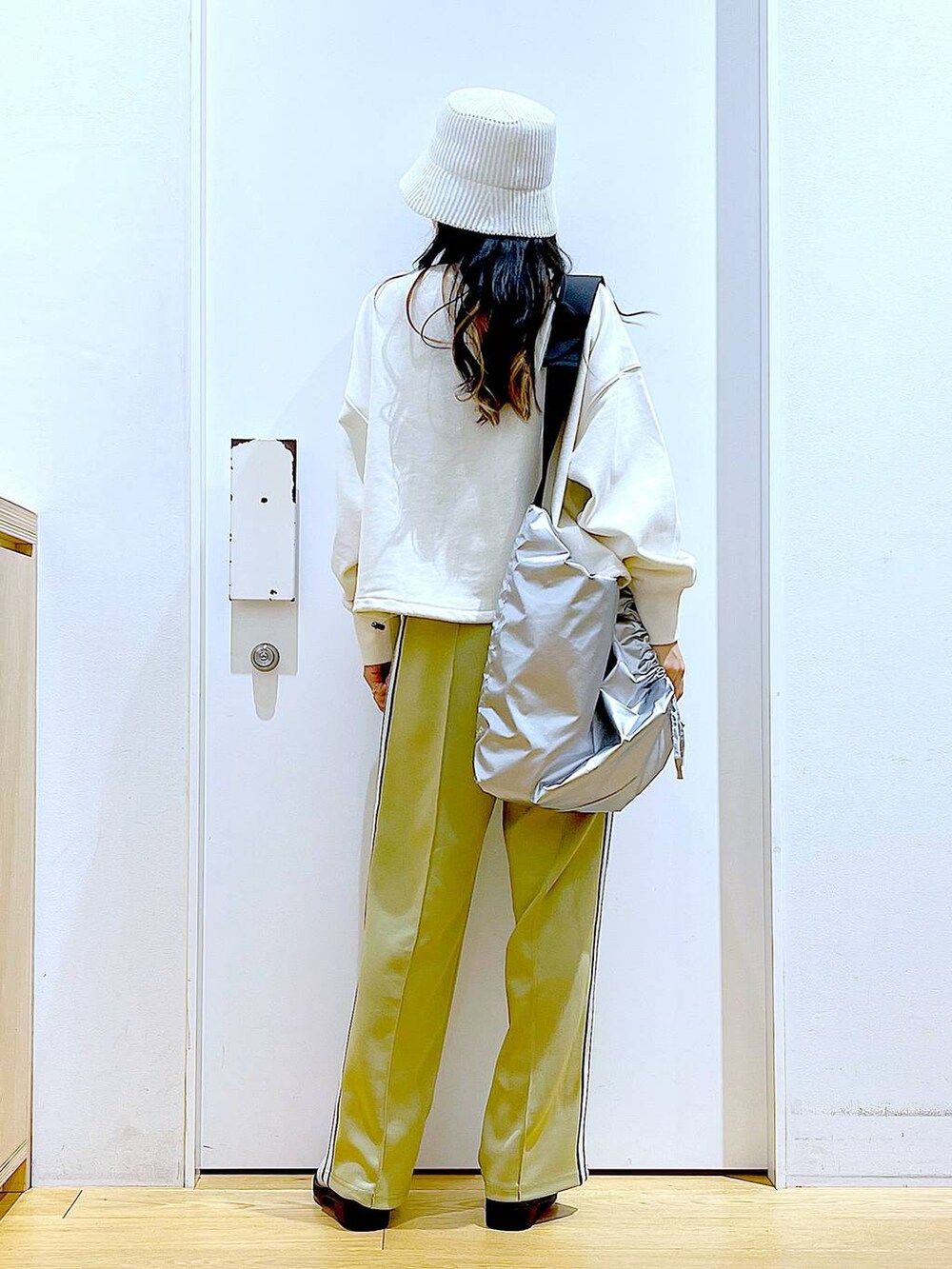 ホワイト系のスウェット、ベージュ系のブーツ、シルバー系のショルダーバッグを着用したレディースの春コーディネートの5枚目の写真