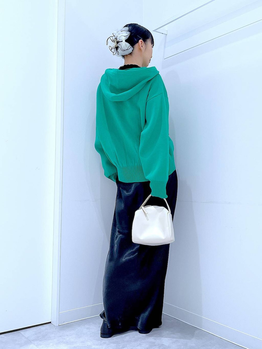 ブラック系のTシャツ/カットソー、ホワイト系のショルダーバッグ、グリーン系のニット/セーターを着用したレディースの春コーディネートの5枚目の写真