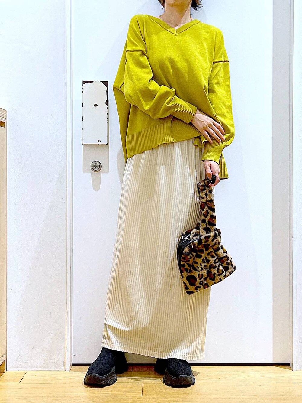 その他のショルダーバッグ、ホワイト系のスカート、ブラック系のブーツを着用したレディースの冬コーディネートの6枚目の写真