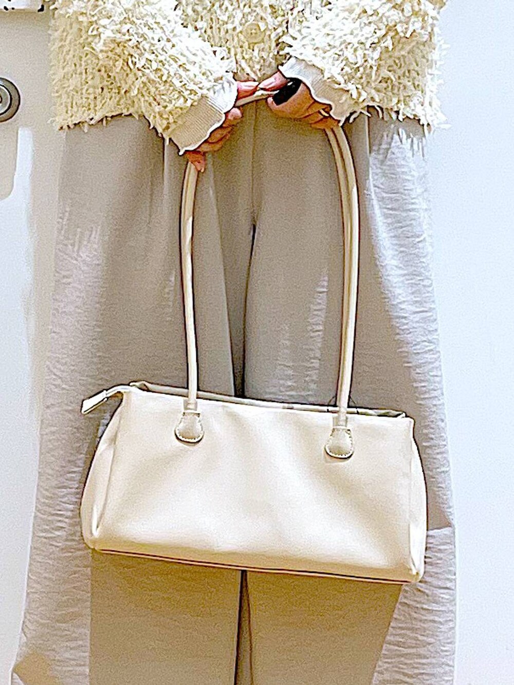 ホワイト系のトートバッグ、ベージュ系のTシャツ/カットソー、シルバー系のパンプスを着用したレディースの冬コーディネートの9枚目の写真