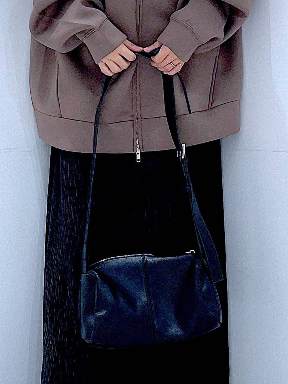 ブラック系のショルダーバッグ、ブラック系のブーツ、ブラウン系のパーカーを着用したレディースの秋コーディネートの9枚目の写真