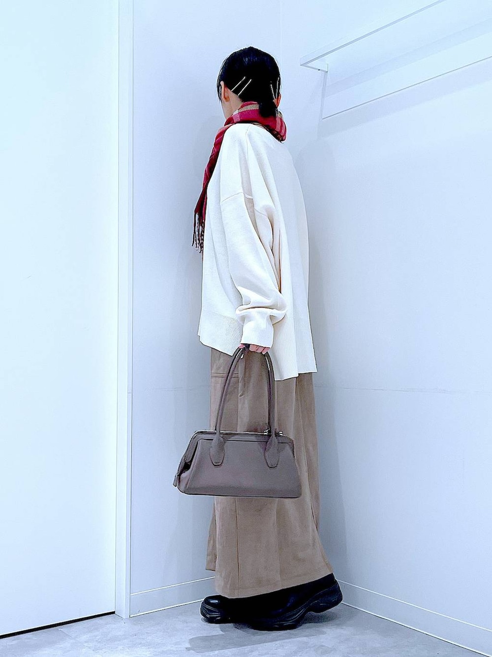 ブラック系のブーツ、ベージュ系のニット/セーター、ブラウン系のスカートを着用したレディースの秋コーディネートの3枚目の写真